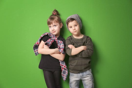 Cute stylish children on color background